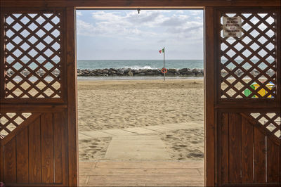 Sea seen through doorway against sky