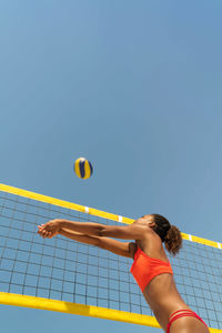 Woman with afro hair playing beach volleyball