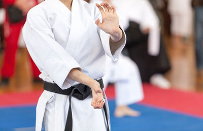 Midsection of man practicing karate on carpet