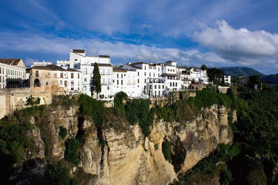 Buildings in city against cloudy sky