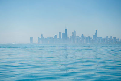 Sea and buildings against clear sky