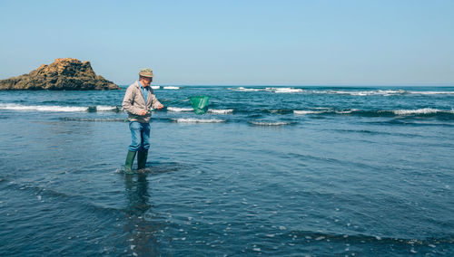 Man standing on beach against clear sky