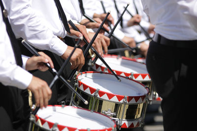 Midsection of musicians playing drum