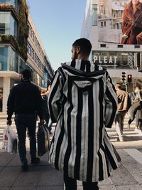 People walking on street against buildings in city