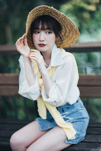 Portrait of young woman wearing hat while standing outdoors