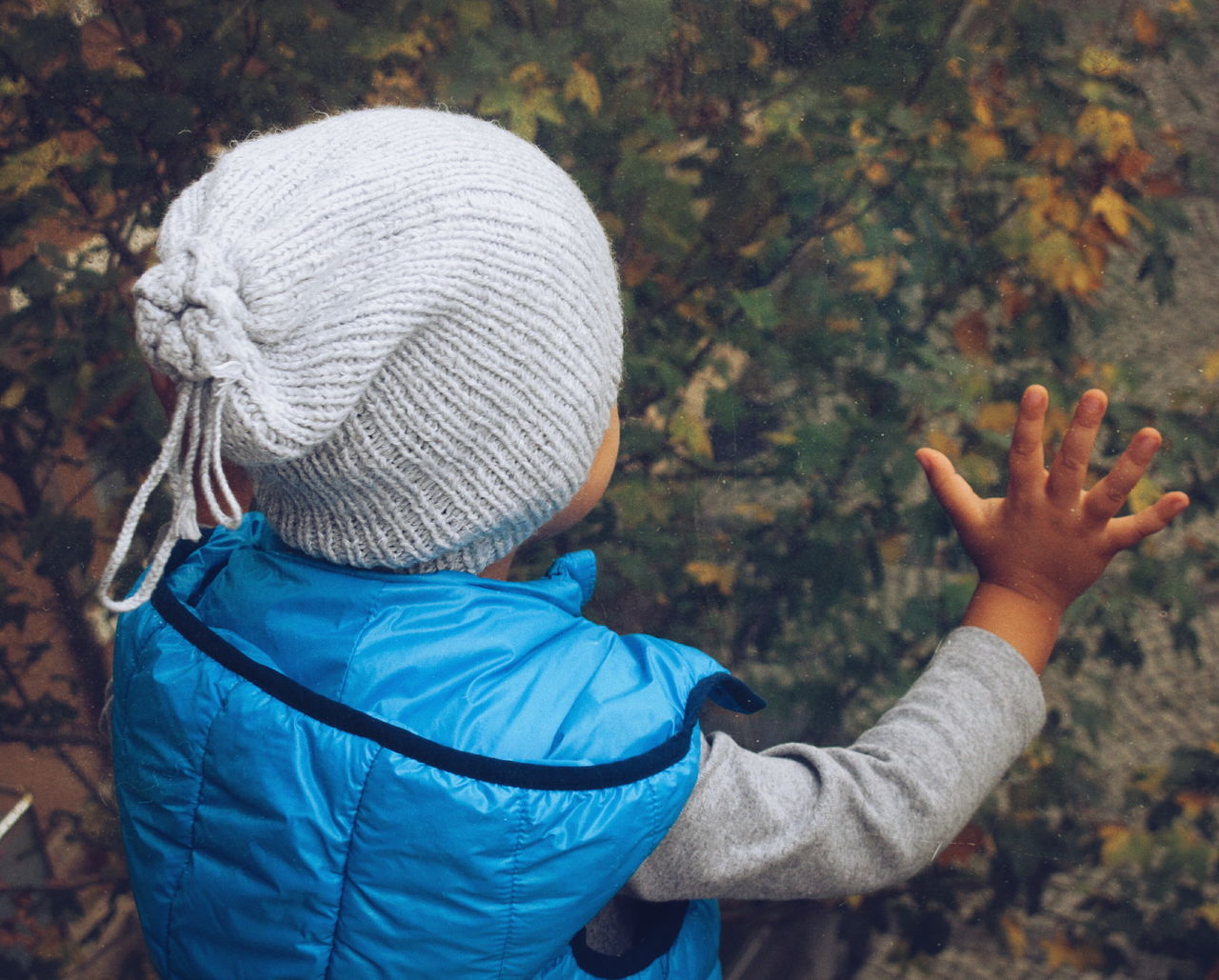 real people, rear view, one person, clothing, hat, child, childhood, leisure activity, knit hat, men, lifestyles, warm clothing, casual clothing, day, headshot, nature, winter, hood, focus on foreground, outdoors, hood - clothing, human arm