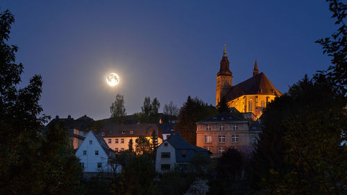 Illuminated buildings against sky at night