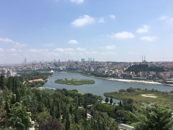 Aerial view of bridge over river in city against sky