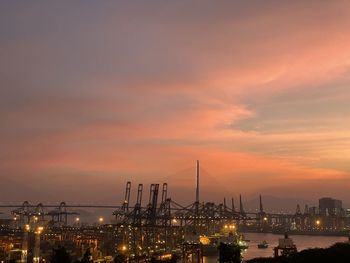 Illuminated buildings against sky during sunset