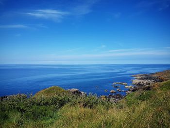 Scenic view of sea against blue sky