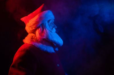 Portrait of man wearing hat against black background