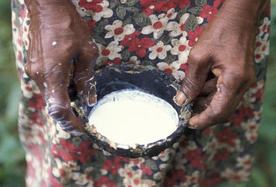Midsection of woman holding rubber sap in bowl