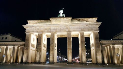 Statue in city at night