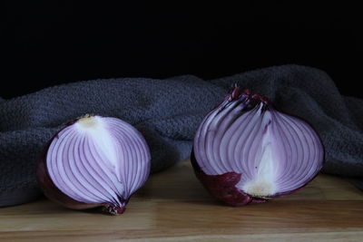 Close-up of garlic on table against black background