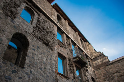 Low angle view of old building against blue sky