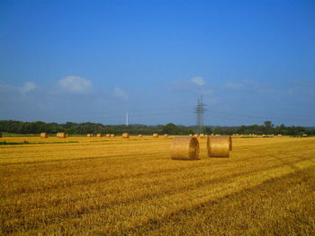 Hay bales on field against sky