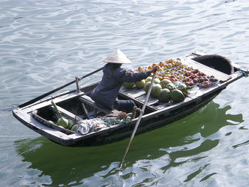 Woman selling fruits on boat at lake