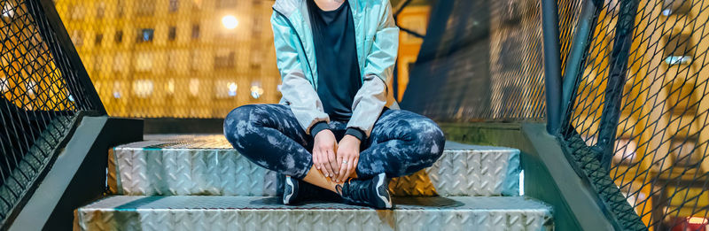 Low section of man standing by railing