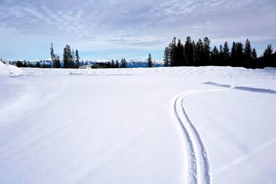 Snow covered landscape against sky