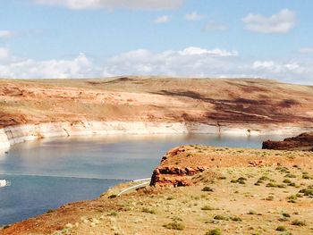 Scenic view of rocks by lake against sky