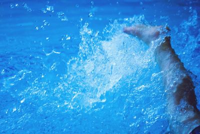 Person splashing water in swimming pool