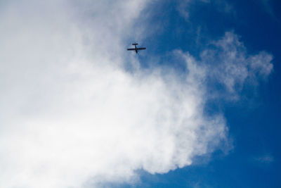 Low angle view of airplane flying against blue sky