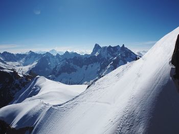 Scenic view of snowcapped mountains against clear blue sky