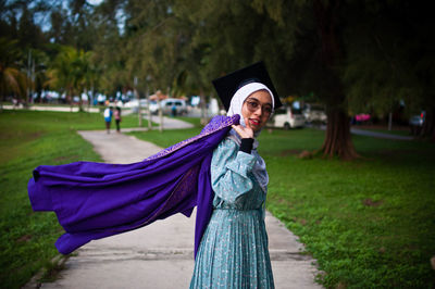 Portrait of smiling young woman standing on land