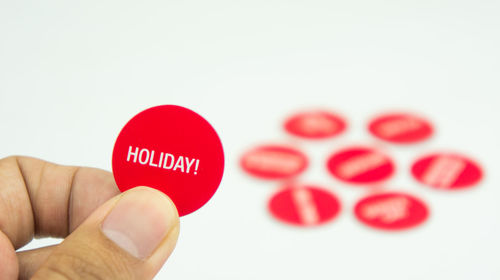 Close-up of hand holding text over white background