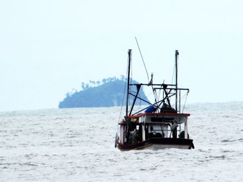 Sailboat in sea against clear sky