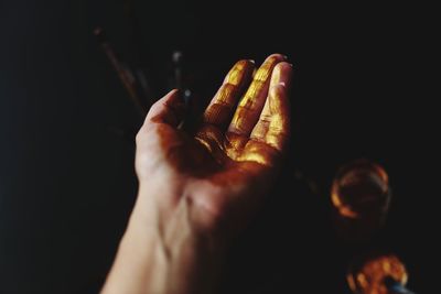 Close-up of human hand against black background