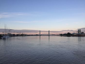 Bridge over river against sky during sunset