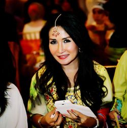 Portrait of a smiling young woman holding camera