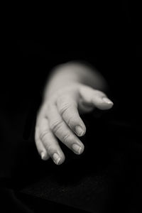 Close-up of human hand against black background