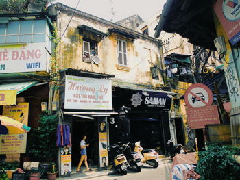 People on street against buildings in city