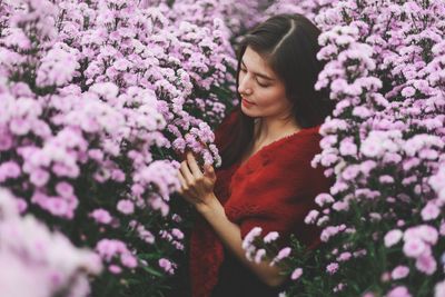 Low angle view of woman on pink flowering plants