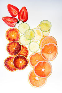 Slices of orange, lemon and fresh strawberries on white backgrou