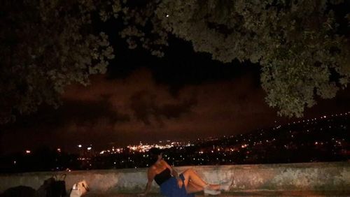 People by illuminated trees at night