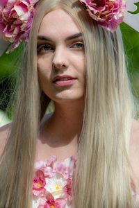 Portrait of beautiful woman with pink flower