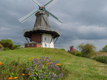 Traditional windmill on field against sky