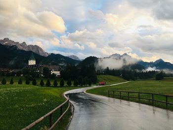 Road leading towards mountains against sky