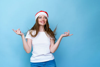 Young woman smiling against blue background