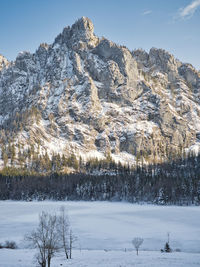 Snow covered land and mountains against sky