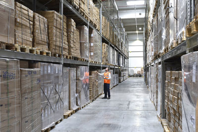 Man in factory hall wearing safety looking up