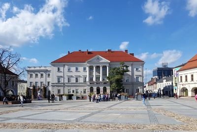 People on street against buildings in city