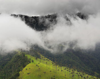 Scenic view of fog on mountain against sky