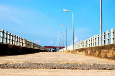 Road by bridge against blue sky