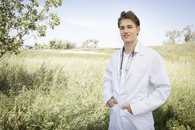 Portrait of female doctor standing on field