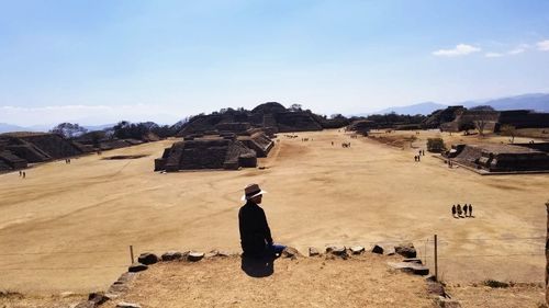 People on arid landscape against sky