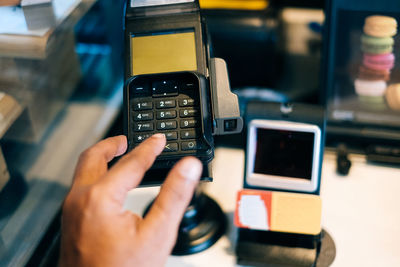 Cropped hand using credit card reader in store